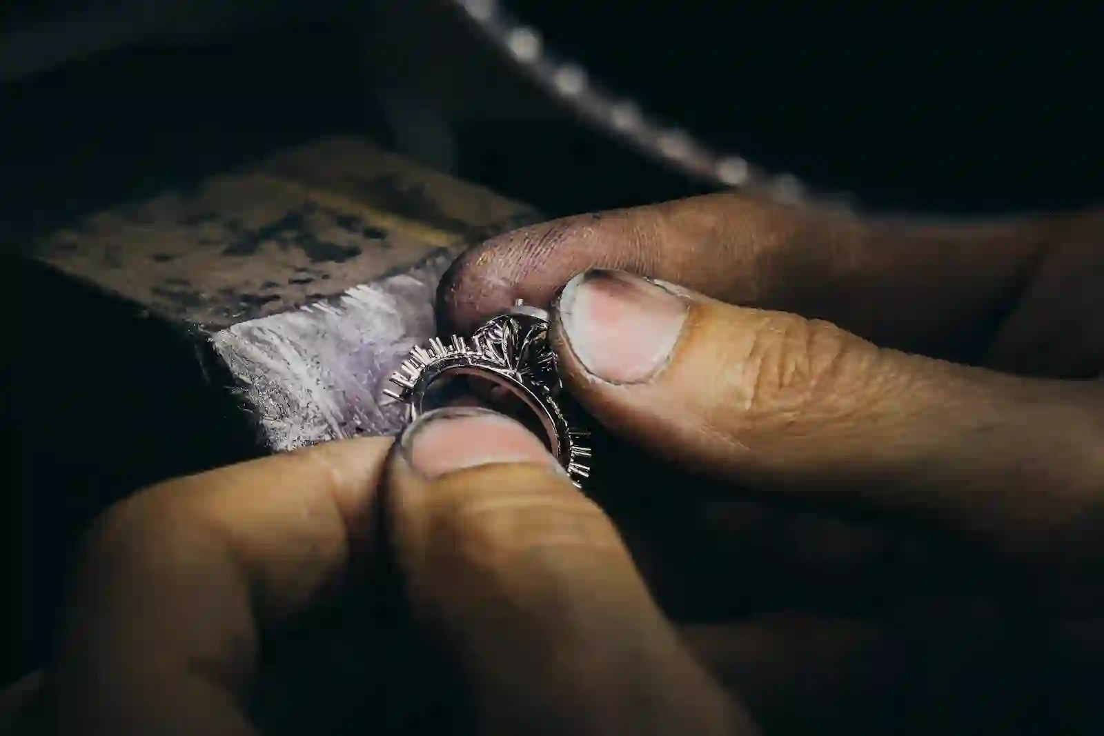 A goldsmith hand-finishing a ring at the workbench